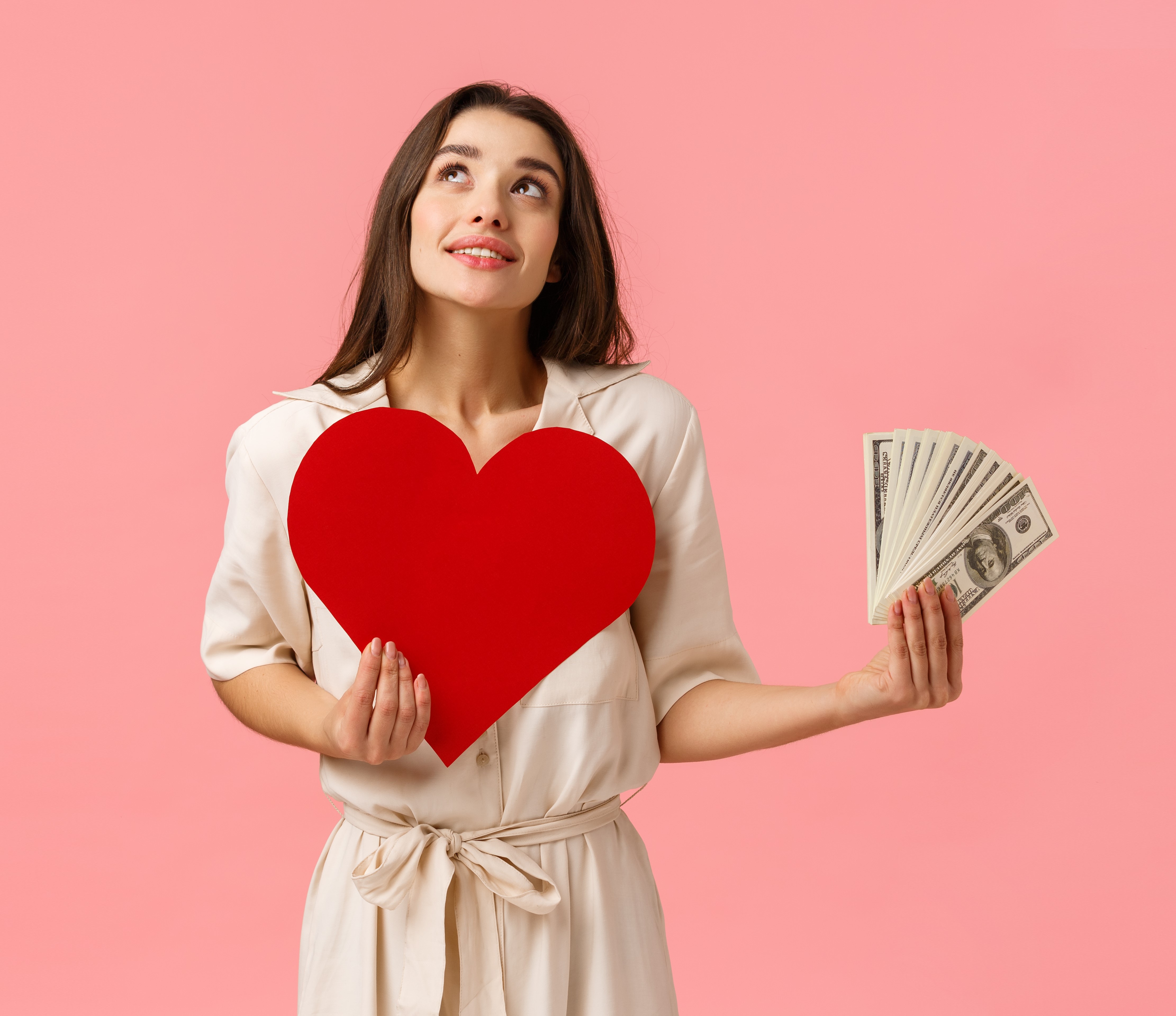 Woman holding heart and money